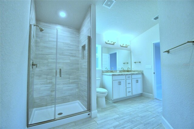 bathroom with tile patterned flooring, walk in shower, toilet, and vanity