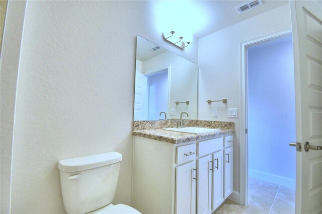 bathroom with vanity, tile patterned flooring, and toilet