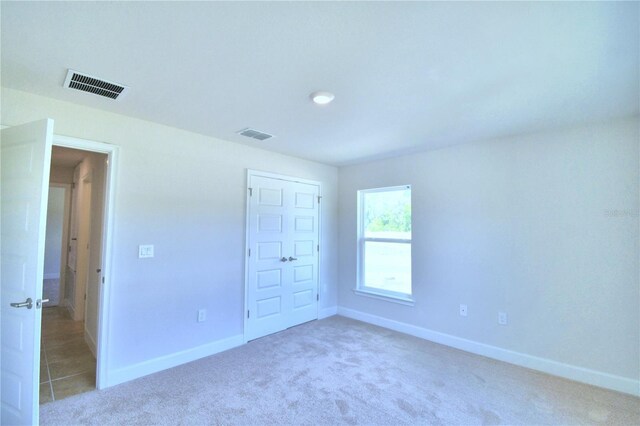 unfurnished bedroom with a closet and carpet floors