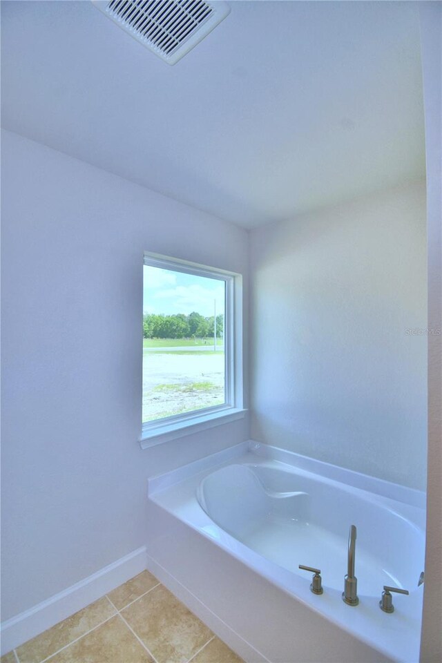 bathroom featuring tile patterned floors and a bath