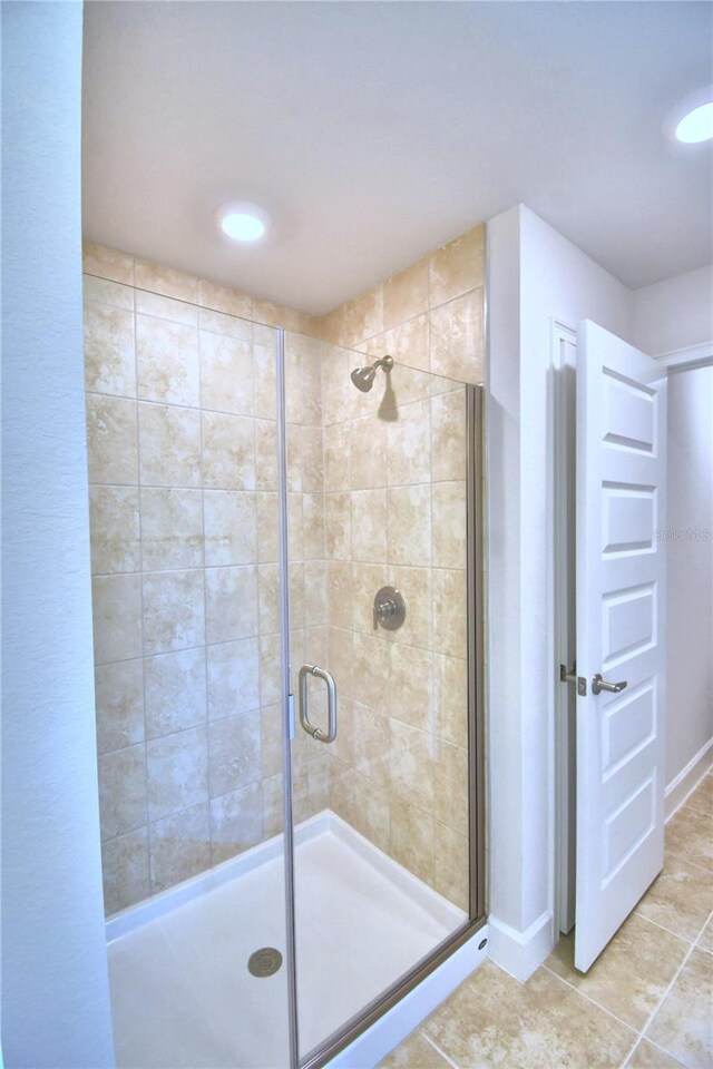 bathroom featuring tile patterned floors and a shower with door