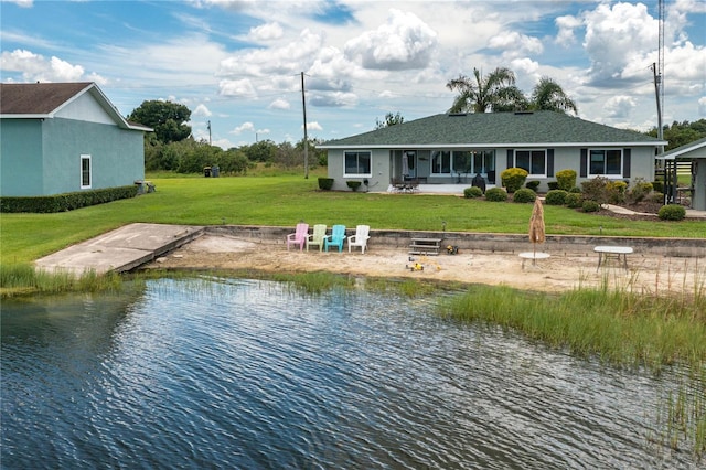 back of house featuring a lawn, a water view, and a patio