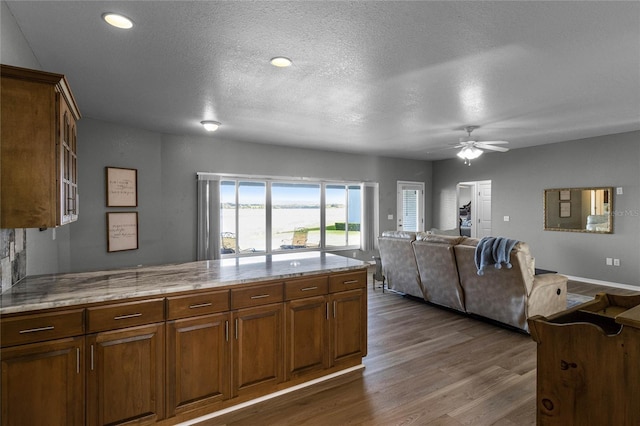 kitchen with a textured ceiling, ceiling fan, and dark hardwood / wood-style floors