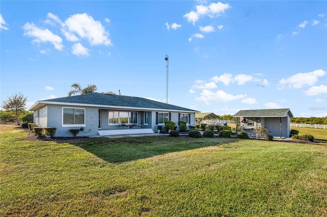 back of property featuring a yard, a shed, and a patio area