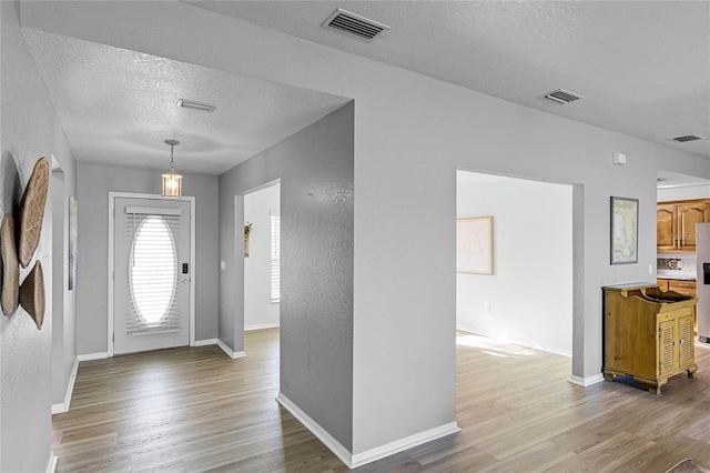 foyer featuring light hardwood / wood-style floors and a textured ceiling