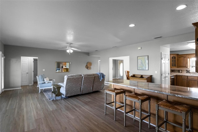 living room with a textured ceiling, dark hardwood / wood-style floors, and ceiling fan