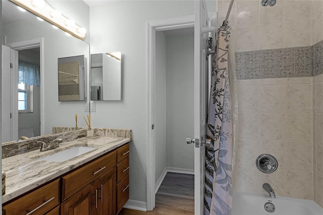 bathroom with wood-type flooring, vanity, and shower / bath combo with shower curtain