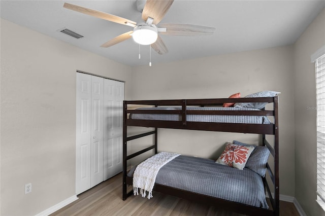 bedroom with hardwood / wood-style floors, ceiling fan, and a closet