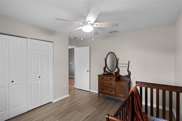 bedroom featuring ceiling fan, wood-type flooring, and a closet