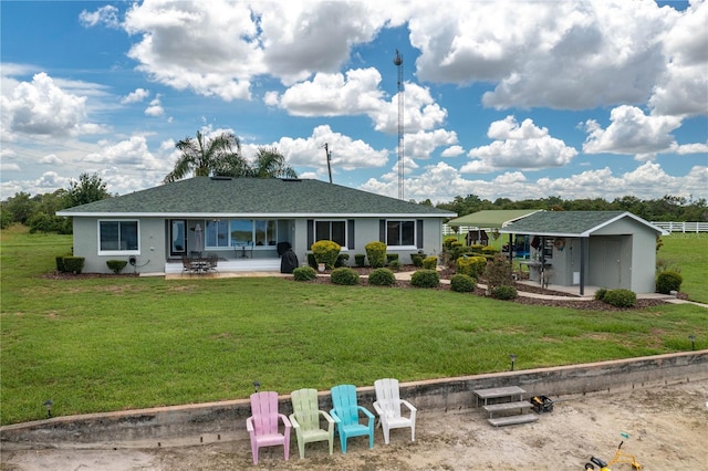 rear view of property with a yard, a patio, and a storage unit