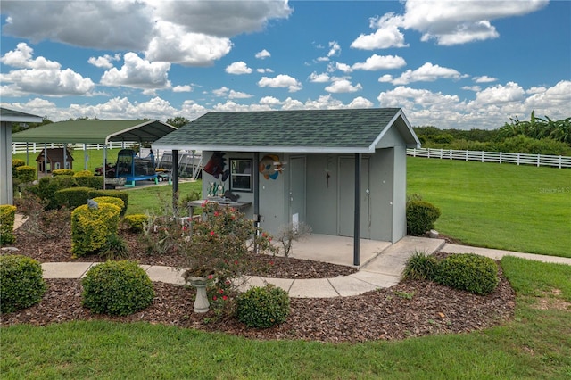 view of outbuilding featuring a carport and a lawn