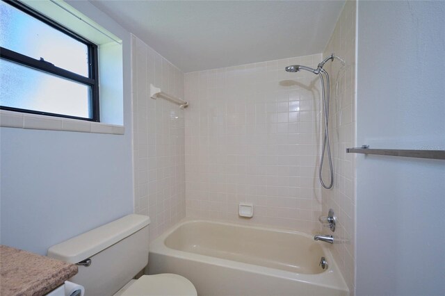 full bathroom with vanity, tiled shower / bath combo, and toilet