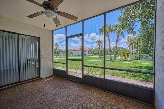 unfurnished sunroom featuring ceiling fan