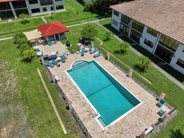 view of pool with a patio and a yard