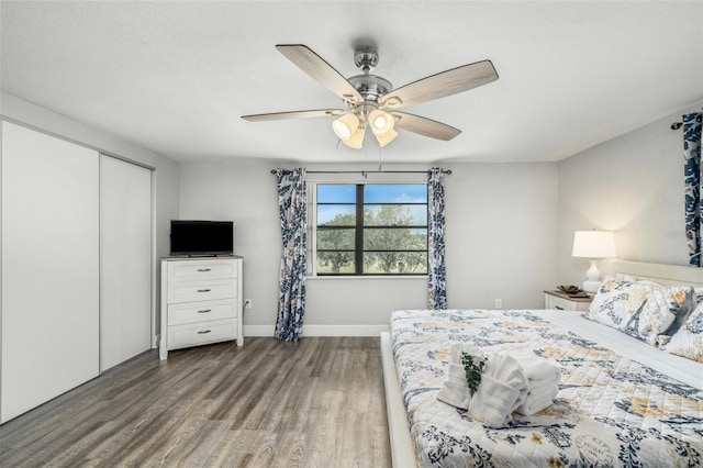 bedroom with dark hardwood / wood-style flooring, a closet, and ceiling fan