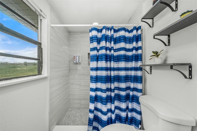 bathroom with curtained shower and toilet