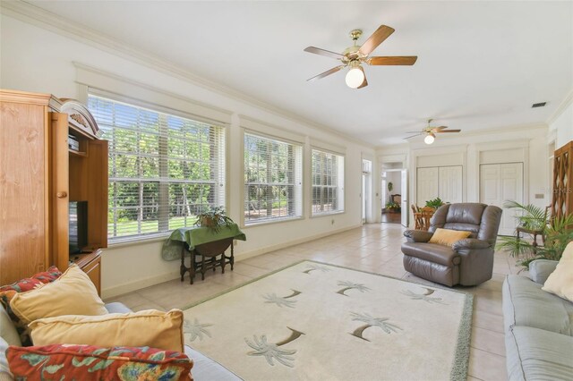 living room featuring tile patterned floors, ceiling fan, plenty of natural light, and crown molding