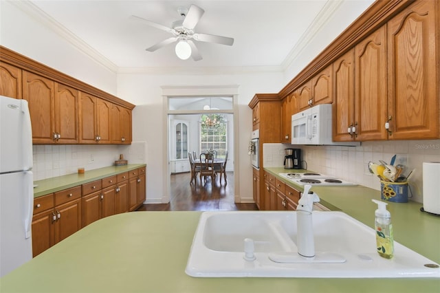 kitchen featuring dark hardwood / wood-style floors, ceiling fan, white appliances, and backsplash