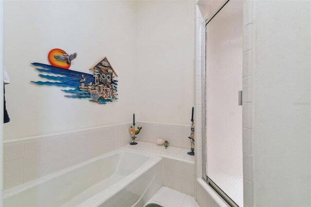 bathroom featuring tile patterned floors and a bath