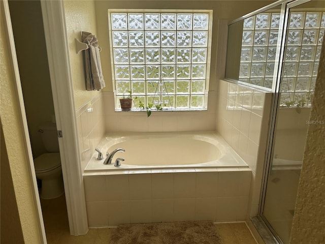 bathroom with independent shower and bath, tile patterned flooring, and toilet