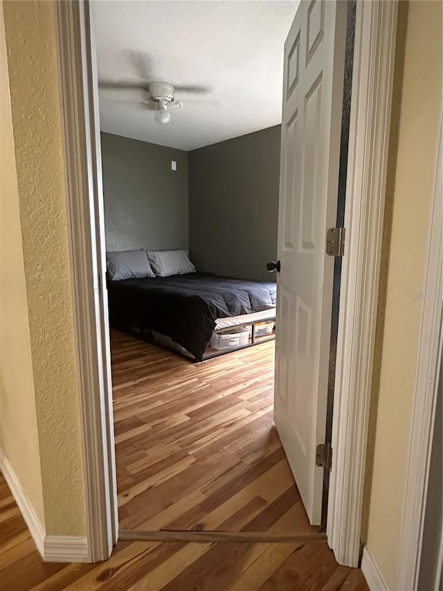 bedroom with ceiling fan and wood-type flooring