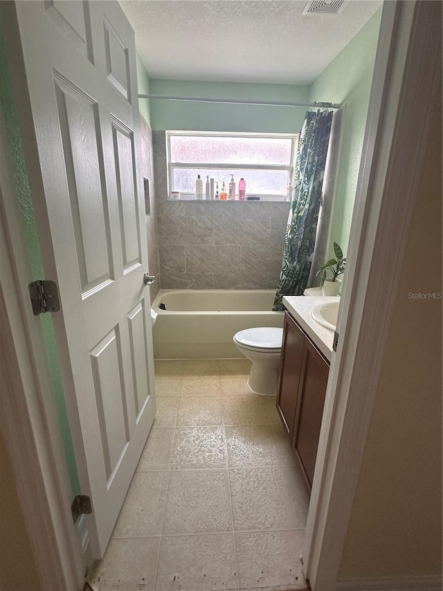 full bathroom with shower / tub combo, a textured ceiling, tile patterned floors, toilet, and vanity