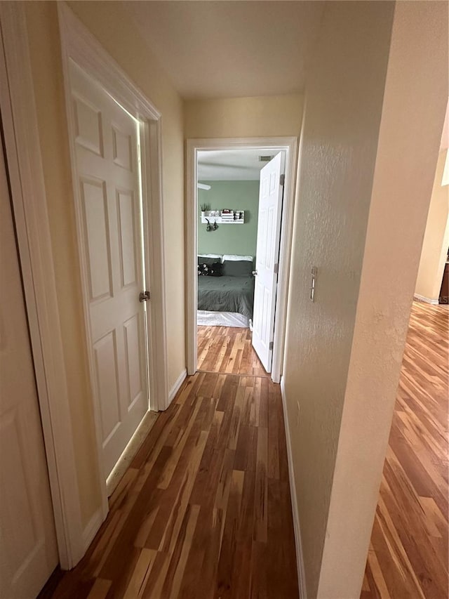 hallway with hardwood / wood-style floors