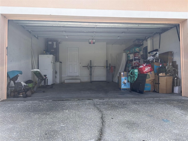 garage featuring white fridge and a garage door opener