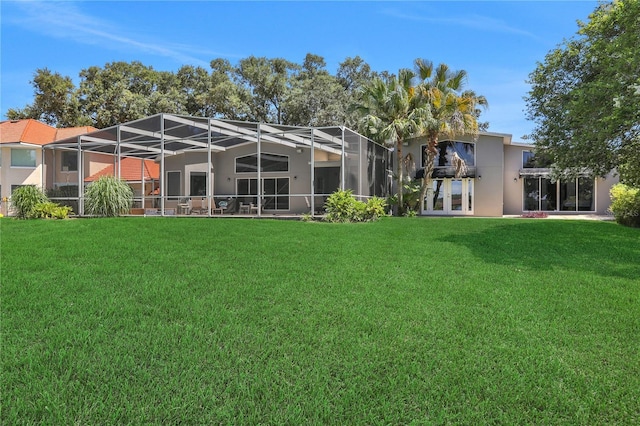 back of property featuring a lanai and a lawn