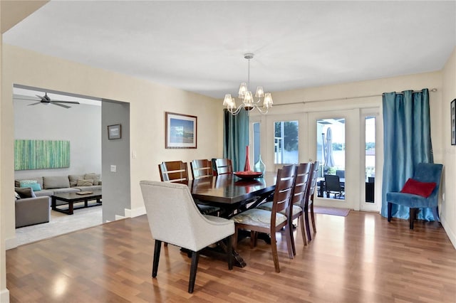 dining area with hardwood / wood-style flooring, a notable chandelier, and french doors