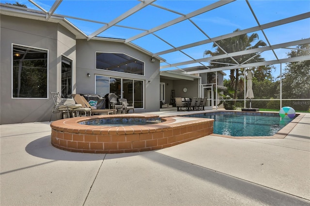 view of pool featuring a patio area, a lanai, and an in ground hot tub