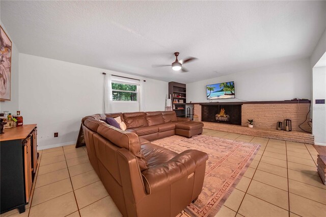 tiled living room with a fireplace, a textured ceiling, and ceiling fan