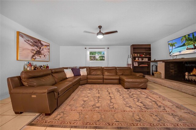 living room with light tile patterned floors, a fireplace, and ceiling fan