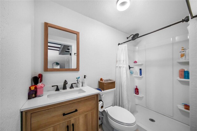 bathroom featuring vanity, toilet, and walk in shower