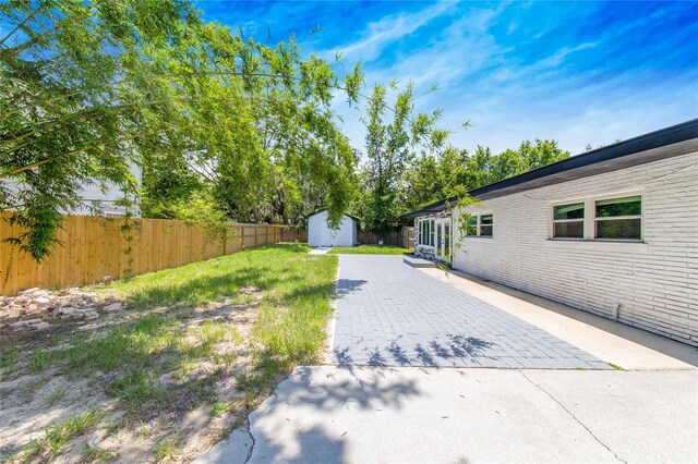 view of yard featuring a patio area and a shed