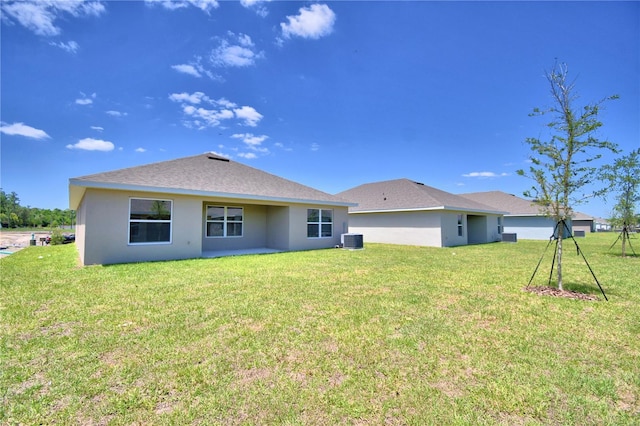 back of house featuring a lawn and central AC unit