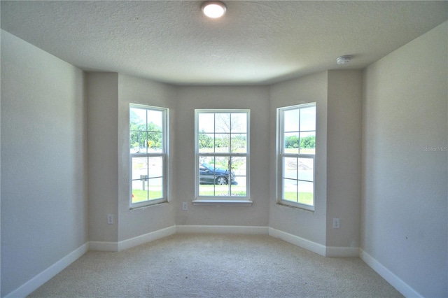 carpeted empty room with a textured ceiling