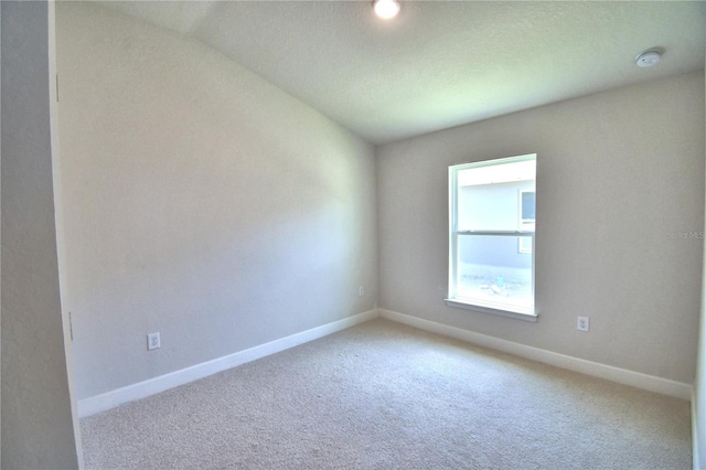 unfurnished room featuring carpet flooring and lofted ceiling