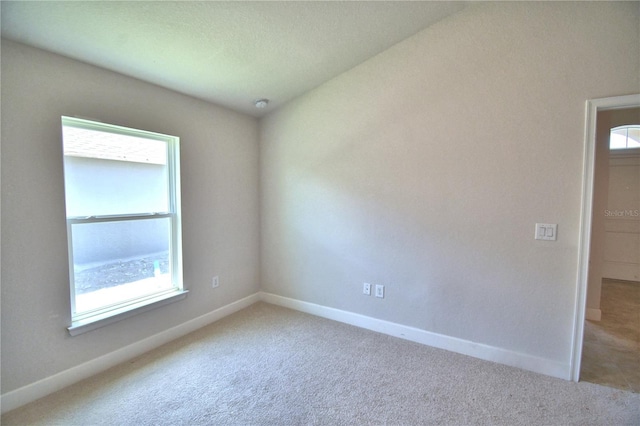 spare room with a healthy amount of sunlight and light colored carpet