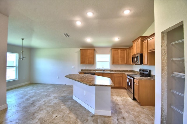 kitchen featuring sink, hanging light fixtures, a notable chandelier, a kitchen island, and appliances with stainless steel finishes