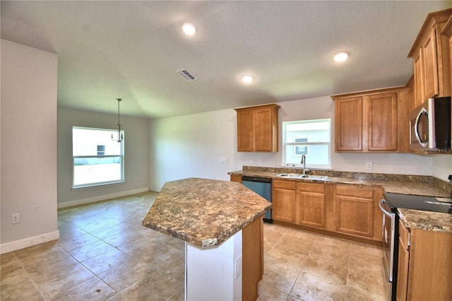 kitchen with a kitchen island, sink, stainless steel appliances, and hanging light fixtures