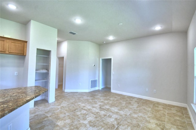 kitchen with built in features and dark stone counters