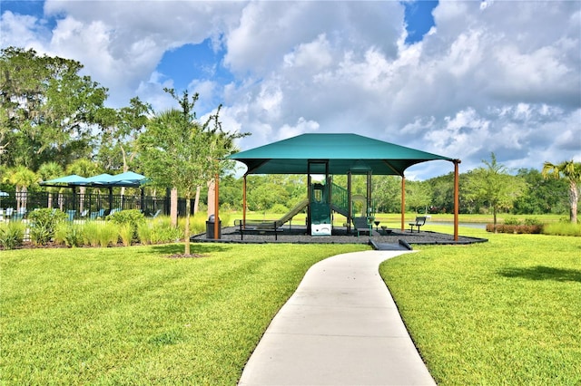 view of property's community with a playground and a lawn