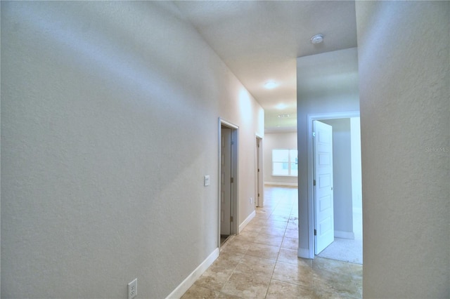 hall featuring light tile patterned flooring