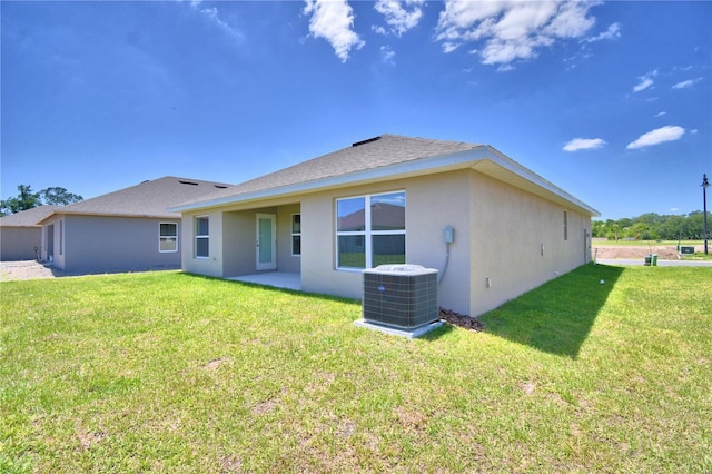 rear view of property with a lawn and cooling unit