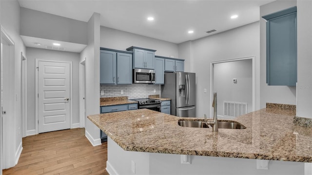 kitchen featuring sink, kitchen peninsula, stainless steel appliances, and a kitchen breakfast bar