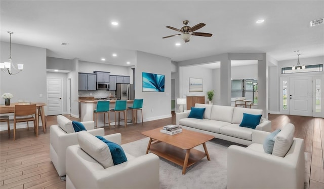 living room featuring light wood-type flooring, baseboards, and recessed lighting