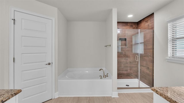 bathroom with a garden tub, vanity, and a stall shower