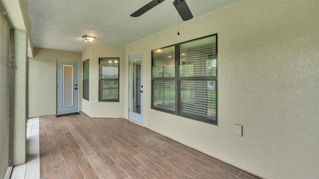 unfurnished sunroom with a ceiling fan