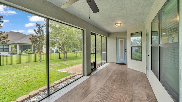 unfurnished sunroom with a ceiling fan